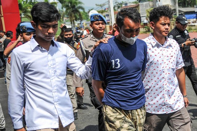 Polisi menggiring tersangka kasus pembacokan mantan Ketua Komisi Yudisial Jaja Ahmad Jayus, Aditya (tengah), saat rilis di Polresta Bandung, Soreang, Kabupaten Bandung, Jawa Barat, Rabu (29/3/2023). Foto: Raisan Al Farisi/ANTARA FOTO