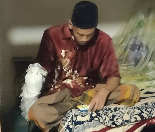 Anak bernama Muksin sesaat setelah membunuh ibunya masih memegang pedang dibalut dengan sorban. (dok. Polres Muba)