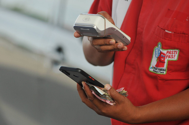 Petugas melayani warga yang melakukan pembelian Bahan Bakar Minyak (BBM) jenis pertalite menggunakan Quick Response (QR) Code di Stasiun Pengisian Bahan Bakar Umum (SPBU) Foto: ANTARA FOTO/Muhammad Izfaldi