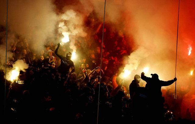 Penggemar Paris Saint-Germain menyalakan suar di tribun sebelum pertandingan di Parc des Princes, Paris, Prancis. Foto: Sarah Meyssonnier/Reuters