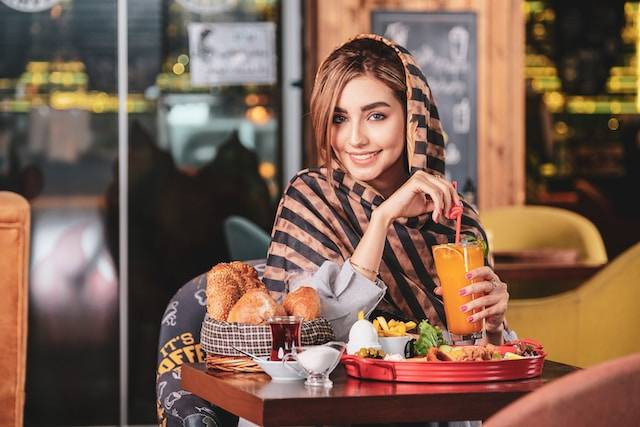Seorang Wanita sedang Menikmati Makanan (sumber: unsplash.com/Sam Moghadam Khamseh)