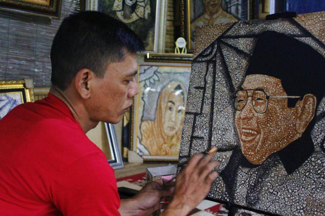 Hakim Abdul saat melukis Gusdur menggunakan cangkang telur. (Foto/Salsyabila Sukma)