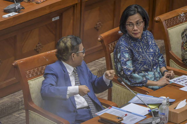 Menko Polhukam yang juga Ketua Komite Koordinasi Nasional PP TPPU Mahfud MD (kiri) berbincang dengan Menteri Keuangan (Menkeu) Sri Mulyani (kanan) saat mengikuti rapat dengar pendapat bersama Komisi III DPR di Kompleks Parlemen, Senayan. Foto: Galih Pradipta/Antara Foto