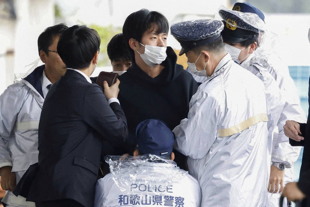 Seorang pria diamankan polisi setelah melemparkan benda mirip pipa ke Perdana Menteri Jepang Fumio Kishida, di Wakayama, Prefektur Wakayama, Jepang barat daya, Sabtu (15/4/2023). Foto: Kyodo/via REUTERS