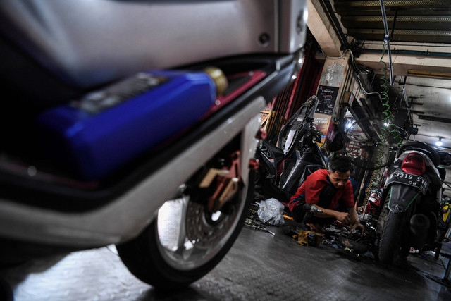 Mekanik memperbaiki motor di salah satu bengkel motor di Pasar Minggu, Jakarta Selatan, Minggu (16/4/2023). Foto: Sigid Kurniawan/ANTARA FOTO