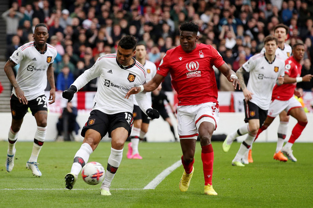 Pemain Manchester United Casemiro berebut bola dengan pemain Nottingham Forest Taiwo Awoniyi pada pertandingan lanjutan Liga Inggris di Stadion The City Ground, Nottingham, Inggris, Minggu (16/4/2023).  Foto: Chris Radburn/REUTERS