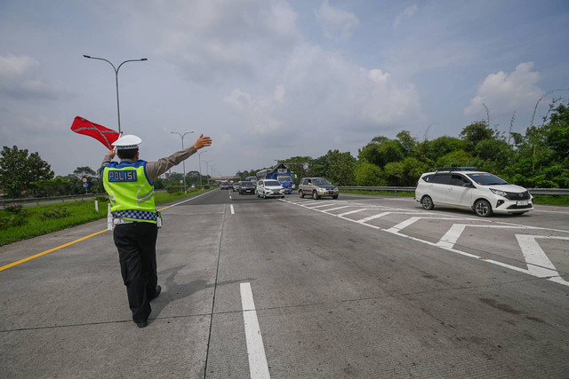 Polisi mengalihkan kendaraan bermotor dari arah Cirebon ke Jakarta untuk keluar melalui Gerbang Tol Subang saat sterilisasi ruas Tol Cipali dalam rangka penerapan kebijakan satu arah di Subang, Jawa Barat, Selasa (18/4/2023). Foto: Aditya Pradana Putra/ANTARA FOTO
