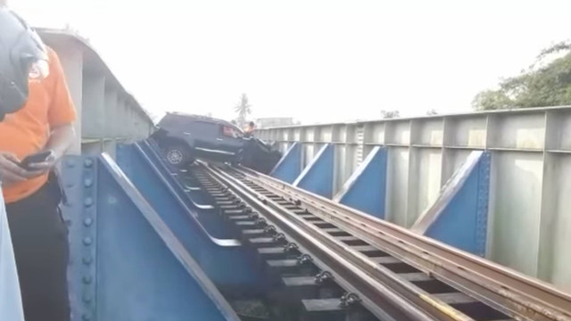Tangkapan layar video yang memperlihatkan mobil memalangi jalur kereta. Dok: Instagram Warung Jurnalis.