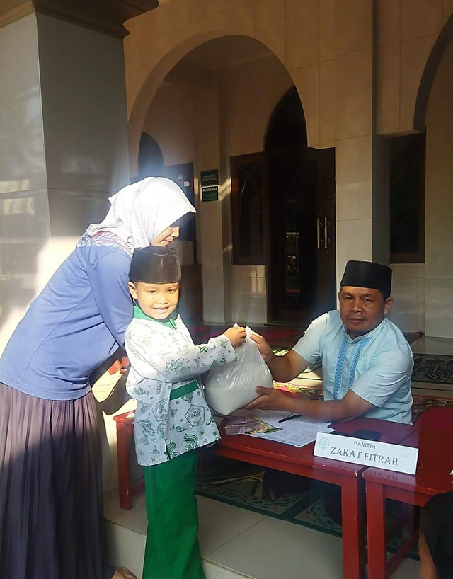 Anak TK Alkautsar didampingi orang tuanya sedang membayarkan zakatnya 