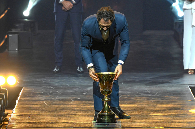 Mantan pemain basket Spanyol dan Anggota Dewan Pusat FIBA, Jorge Joaquin Garbajosa, menempatkan trofi di atas panggung selama pengundian resmi Piala Dunia Basket di Araneta Coliseum, Filipina, pada 29 April 2023. Foto: JAM STA ROSA / AFP
