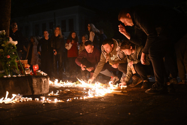 Sejumlah warga memberikan penghormatan terakhir usai insiden penembakan di SD Vladislav di Ribnika di ibu kota Serbia, pada Rabu (3/5/2023). Foto: Andrej Isakovic/AFP