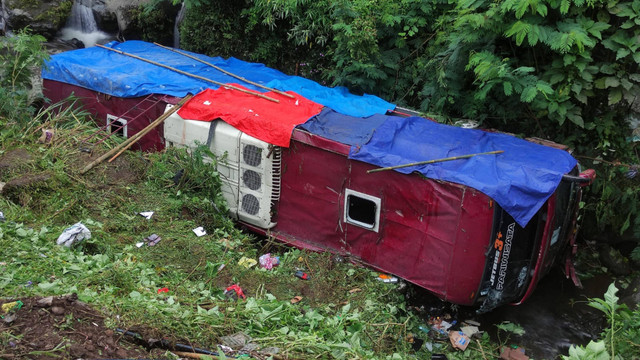 Satu unit bus dalam posisi terbalik usai jatuh ke dalam jurang di kawasan objek wisata Guci, Kabupaten Tegal, Jawa Tengah, Minggu (7/5/2023). Foto: Antara Foto