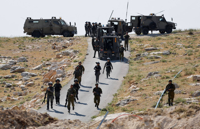 Pasukan Israel mengambil posisi selama bentrokan antara warga Palestina dan pasukan Israel setelah mesin Israel menghancurkan sekolah dekat Bethlehem di Tepi Barat yang diduduki Israel, Minggu (7/5/2023). Foto: Mussa Qawasma/REUTERS