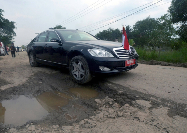 Mobil dinas Presiden Joko Widodo melintas di jalan yang rusak saat meninjau jalan rusak di Kampung Rama Nirwana, Seputih raman, Lampung Tengah, Lampung, Jumat (5/5/2023). Foto: Ardiansyah/Antara Foto