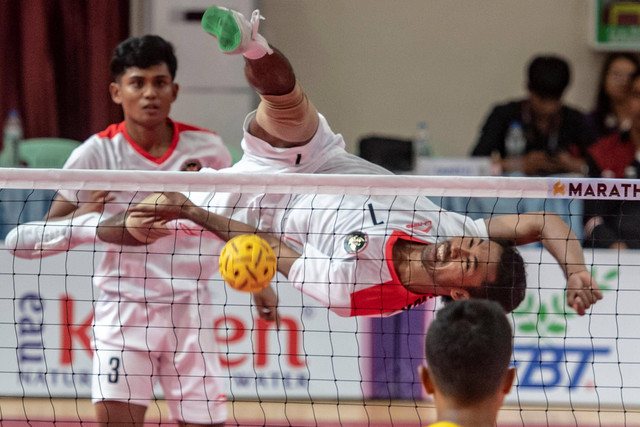 Pesepak takraw Indonesia Saiful Rizal (kanan) dan Muhammad Hardiansyah Muliang (kiri) melakukan rejaman (smash) ke arah tim Myanmar pada pertandingan final sepak takraw beregu putra SEA Games 2023 di National Olympic Stadium, Phnom Penh, Kamboja. Foto: Muhammad Adimaja/Antara Foto