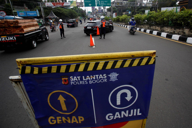 Petugas Sat Lantas Polres Bogor dan petugas Dishub Kabupaten Bogor mengarahkan mobil wisatawan saat penyekatan kendaraan bernomor polisi ganjil genap di jalur wisata Puncak, Gadog, Kabupaten Bogor, Jawa Barat, Kamis (18/5/2023). Foto: Yulius Satria Wijaya/ANTARA FOTO