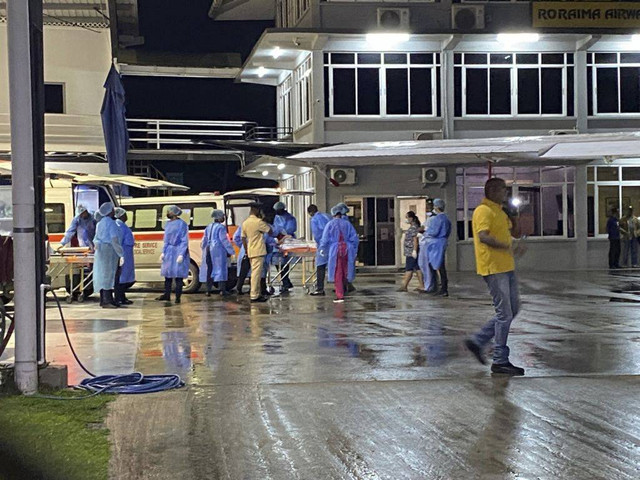 Kru gabungan menyelamatkan dan memindahkan korban kebakaran di Guyana ke rumah sakit. Foto: Royston Drakes/AFP