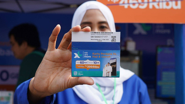 Petugas XL Axiata menunjukkan Kartu Perdana XL Haji di Embarkasi Asrama Haji Pondok Gede, Jakarta. Rabu (24/5). Foto: Dok. XL Axiata
