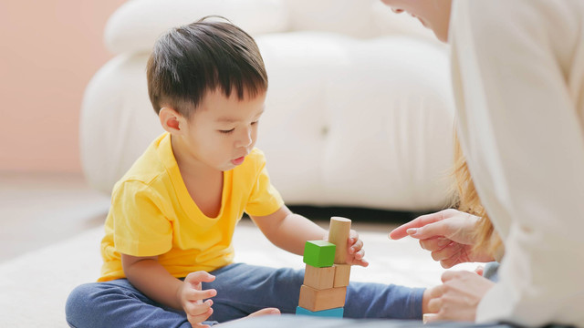 Seorang anak bermain menyusun balok kayu. Foto: aslysun/Shutterstock
