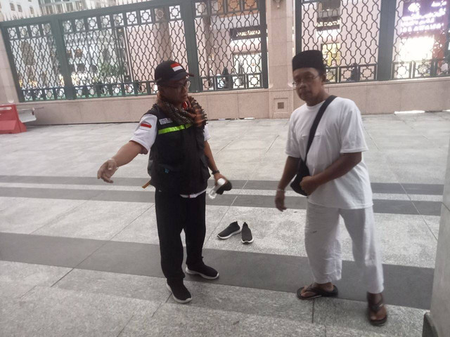 Mahmudin (kanan), jemaah haji Indonesia yang tetap berjalan menuju Masjid Nabawi meski kaki terserang stroke. Foto: Dok. MCH 2023