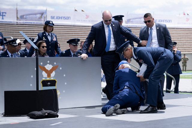 Presiden AS Joe Biden ditolong setelah terjatuh saat upacara kelulusan di Akademi Angkatan Udara Amerika Serikat, tepat di utara Colorado Springs di El Paso County, Colorado, Kamis (1/6/2023). Foto: Brendan Smialowski/AFP