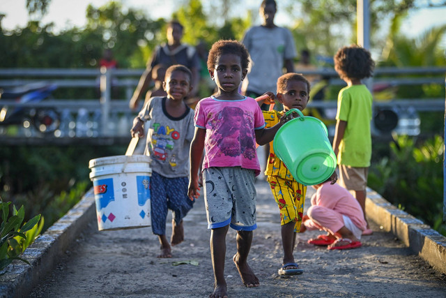 Sejumlah anak membawa ember untuk mengambil air bersih dari reservoir penampung air hujan fasilitas dari pemerintah di Distrik Agats, Kabupaten Asmat, Papua Selatan, Jumat (2/6/2023).  Foto: Aditya Pradana Putra/ANTARA FOTO