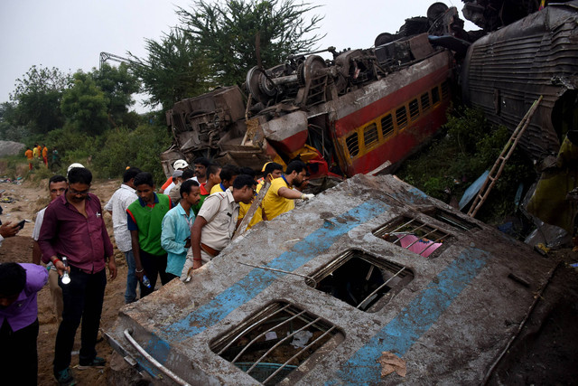 Warga berkerumun di lokasi tabrakan kereta di distrik Balasore di negara bagian timur Odisha, India, 3 Juni 2023. Foto: REUTERS/Stringer