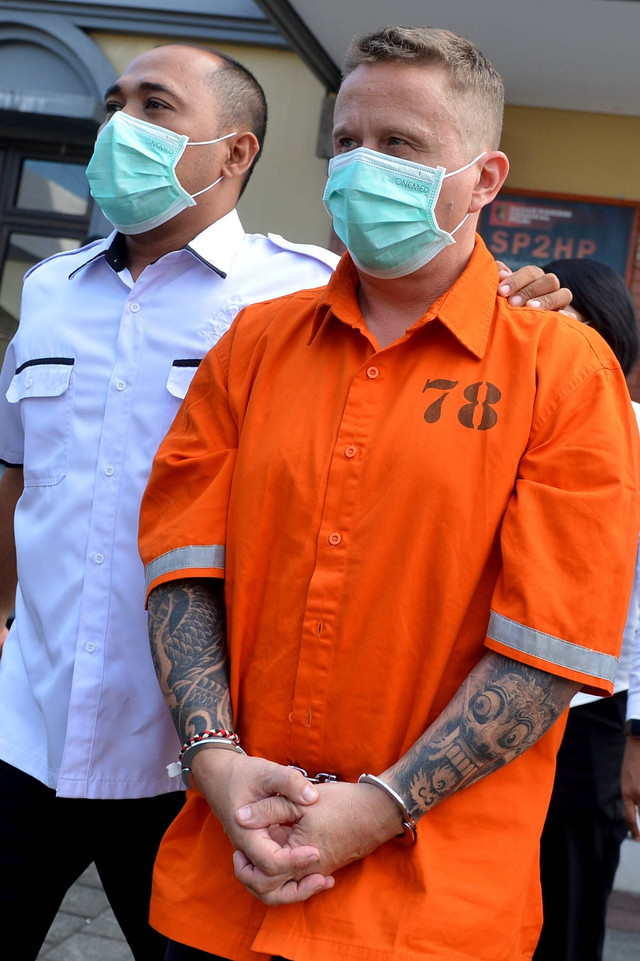 Polisi menggiring warga negara Kanada berinisial SG (kanan) di Gedung Ruang Pelayanan Khusus (RPK) Polda Bali, Denpasar, Bali, Senin (22/5/2023). Foto: Fikri Yusuf/ANTARA FOTO