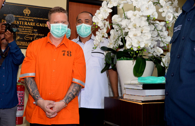 Polisi menggiring warga negara Kanada berinisial SG (kanan) di Gedung Ruang Pelayanan Khusus (RPK) Polda Bali, Denpasar, Bali, Senin (22/5/2023). Foto: Fikri Yusuf/ANTARA FOTO