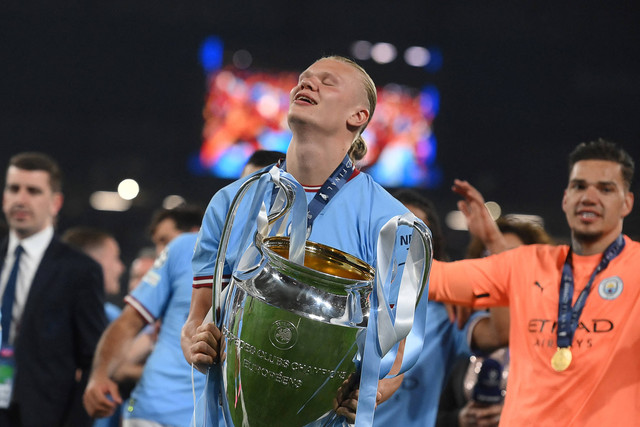 Erling Haaland mengangkat trofi Liga Champions usai Manchester City kalahkan Inter Milan dalam laga finall di Ataturk Olympic Stadium, Turki, Minggu (11/6/2023) dini hari WIB. Foto: FRANCK FIFE / AFP