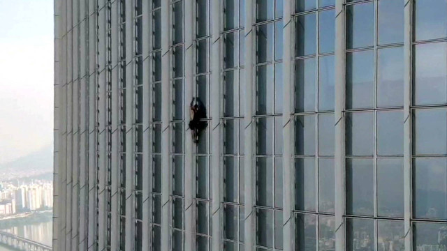 Seorang pria Inggris memanjat gedung tertinggi Korea Selatan, Lotte World Tower 123 lantai, tanpa tali sebelum dipaksa meninggalkan pendakian lebih dari setengah jalan, di Seoul, Korea Selatan, 12 Juni 2023. Foto: Songpa Korea Selatan via REUTERS