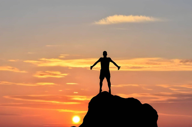 Ilustrasi seorang pria di atas gunung ketika matahari terbenam. Foto: Shutterstock