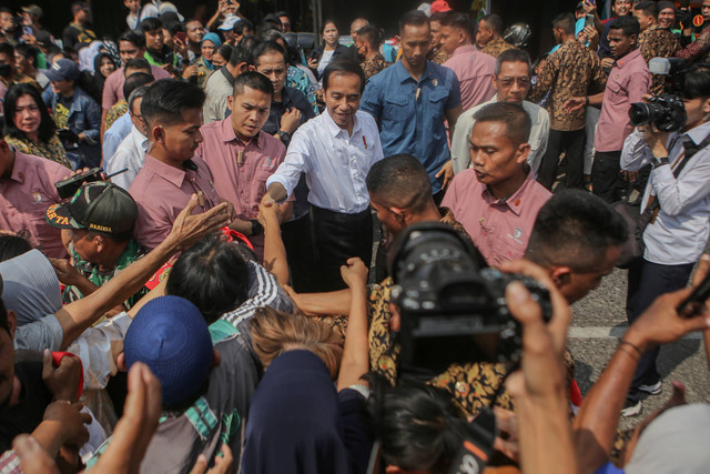 Presiden Joko Widodo (tengah) menyapa warga saat kunjungannya ke Pasar Menteng Pulo, Jakarta, Kamis (15/6/2023). Foto: Fauzan/Antara Foto