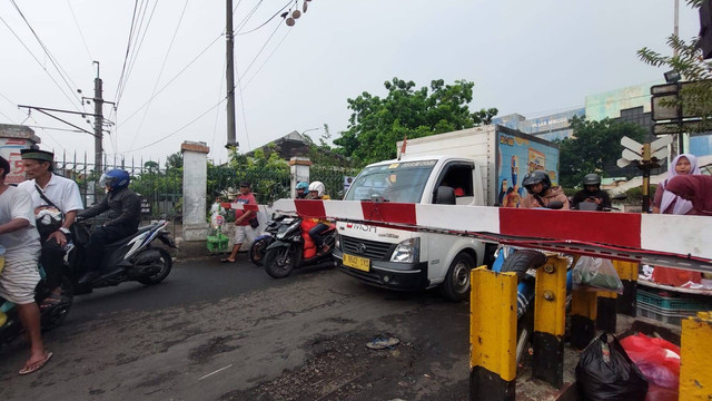 Suasana di pintu perlintasan KA Pasar Minggu yang sedang diuji coba ditutup. Tampak masih banyak kendaraan yang melintas pada Jumat (16/6/2023) pagi. Foto: Nabila Ulfa Jayanti/kumparan