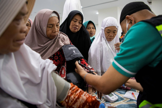 Seorang petugas kesehatan kloter mengecek tensi jemaah lansia kloter SOC 20 usai mengikuti senam di Hotel Bilal Sektor 10, Mekah, Arab Saudi, Sabtu (17/6/2023). Foto: Wahyu Putro A/ANTARA FOTO