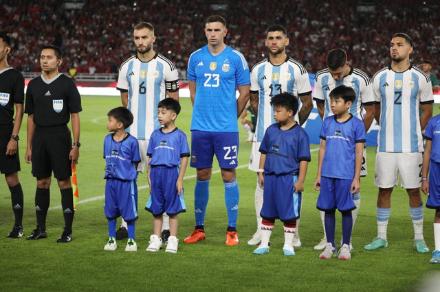 Jan Ethes Srinarendra (kedua kiri) menjadi player escort atau maskot anak saat pertandingan Timnas Indonesia melawan Timnas Argentina pada pertandingan FIFA Matchday di Stadion Utama Gelora Bung Karno, Jakarta, Senin (19/6/2023). Foto: Aditia Noviansyah/kumparan