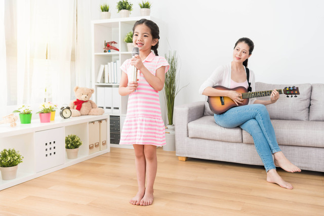 Ibu rumah tangga dan anak perempuan bernyanyi. Foto: PR Image Factory/Shutterstock.