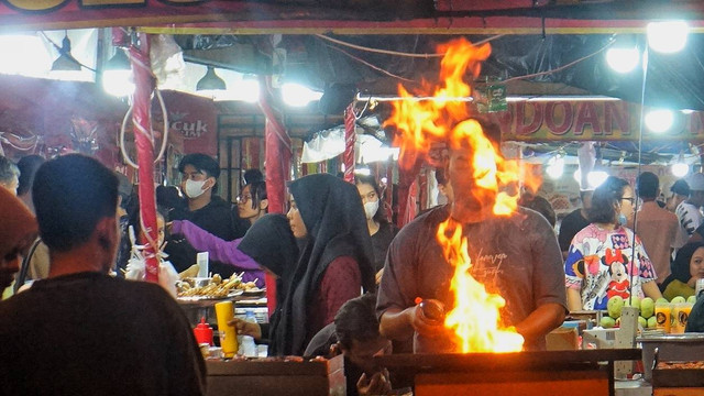 Seorang pemilik tenan di Festival Foodies Palembang yabg sedang memasak sea food di depan pengunjung event, Selasa (27/6) Foto: abp/urban id