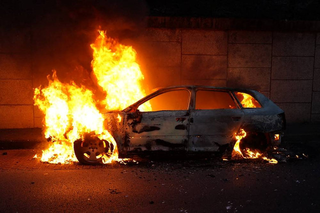 Pemadam kebakaran memadamkan api di mobil yang terbakar pada aksi demo terkait polisi Prancis yang menembak remaja 17 tahun. Foto: AFP/ZAKARIA ABDELKAFI