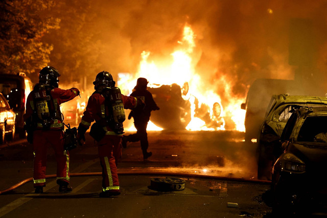 Kendaraan yang terbakar selama bentrokan antara pengunjuk rasa dan polisi, setelah kematian Nahel, seorang remaja berusia 17 tahun yang dibunuh oleh seorang petugas polisi Prancis, di Nanterre, pinggiran Paris, Prancis, Rabu (28/6/2023). Foto: Stephanie Lecocq/REUTERS