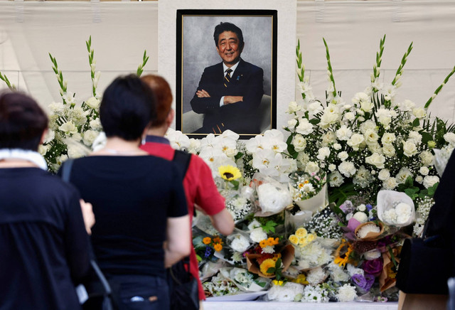 Sejumlah pelayat berdoa untuk mendiang Perdana Menteri Jepang Shinzo Abe, dalam upacara peringatan satu tahun pembunuhannya di kuil Zojoji, Tokyo, Jepang, Sabtu (8/7/2023). Foto: Issei Kato/REUTERS