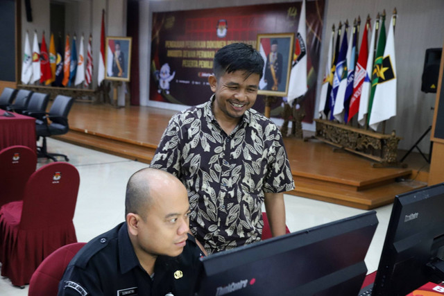 Komisioner KPU RI, Idham Kholik, meninjau petugas KPU yang melakukan perbaikan dokumen persyaratan bakal calon anggota dewan perwakilan rakyat oleh partai politik peserta pemilu serentak tahun 2024 di Gedung KPU, Jakarta, Minggu (9/7/2023). Foto: Fitra Andrianto/kumparan