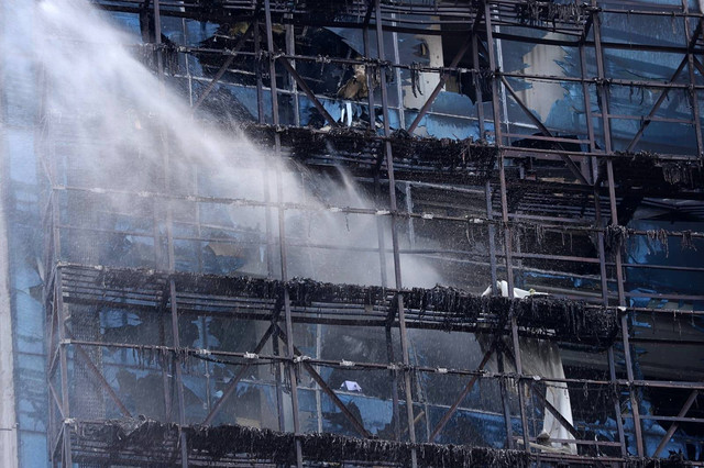 Petugas pemadam kebakaran dalam proses pendinginan di gedung K-Link Gatot Subroto, Jakarta, usai kebakaran, Sabtu (15/7/2023). Foto: Jamal Ramadhan/kumparan