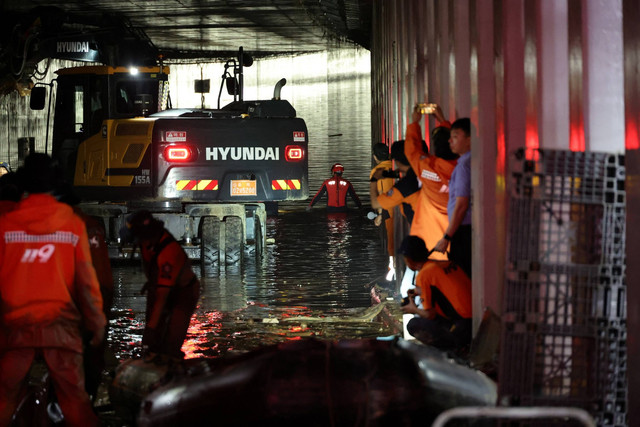 KoPetugas penyelamat ikut dalam operasi pencarian dan penyelamatan di dalam underpass yang terendam banjir akibat hujan deras di Cheongju, Korea Selatan, Minggu (16/7/2034). Foto: Yonhap/via REUTERS 