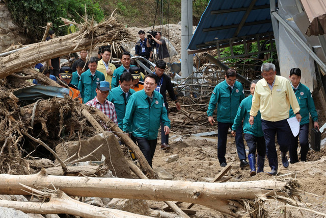 Presiden Korea Selatan Yoon Suk Yeol (tengah) mengunjungi sebuah desa terdampak tanah longsor, di Yecheon, Korea Selatan, Senin (17/7/2023). Foto: Yonhap/AFP