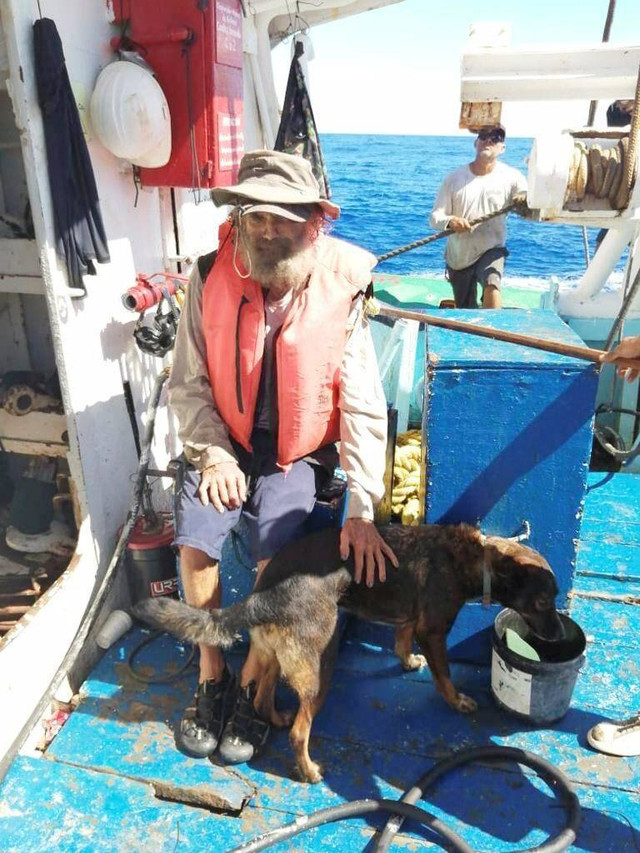 Tim Shaddock dari Australia duduk bersama anjingnya Bella setelah diselamatkan oleh kapal tuna Meksiko di perairan internasional, setelah terapung-apung bersama anjingnya selama tiga bulan. Foto: Grupomar/Atun Tuny via AP