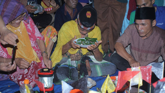 tetua adat masyarakat melayu perhiasan menyampaikan mantra pada prosesi tradisi hanyut langcang masyarakat melayu, desa perhaisan (foto dokumentasi pribadi)