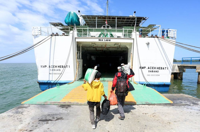 Calon penumpang berjalan menuju Kapal Motor Penyeberangan (KMP) Aceh Hebat 1 di dermaga Pelabuhan Penyeberangan Meulaboh-Sinabang Desa Gampong Teugoh, Aceh Barat, Aceh, Selasa (25/7/2023). Foto: ANTARA FOTO/Syifa Yulinnas