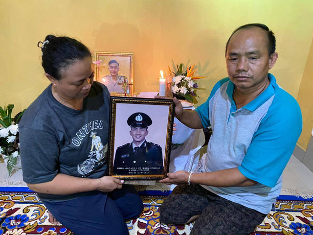 Y Pandi dan istrinya Inosensia Antonia Tarigas memperlihatkan foto anaknya dengan seragam Polri. Foto: Yusrizal/Hi!pontianak