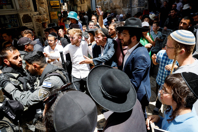 Orang-orang Yahudi berdoa di luar kompleks Masjid Al-Aqsa yang juga dikenal orang Yahudi sebagai Temple Mount di Kota Tua Yerusalem, Kamis (27/7/2023). Foto: Ammar Awad/Reuters